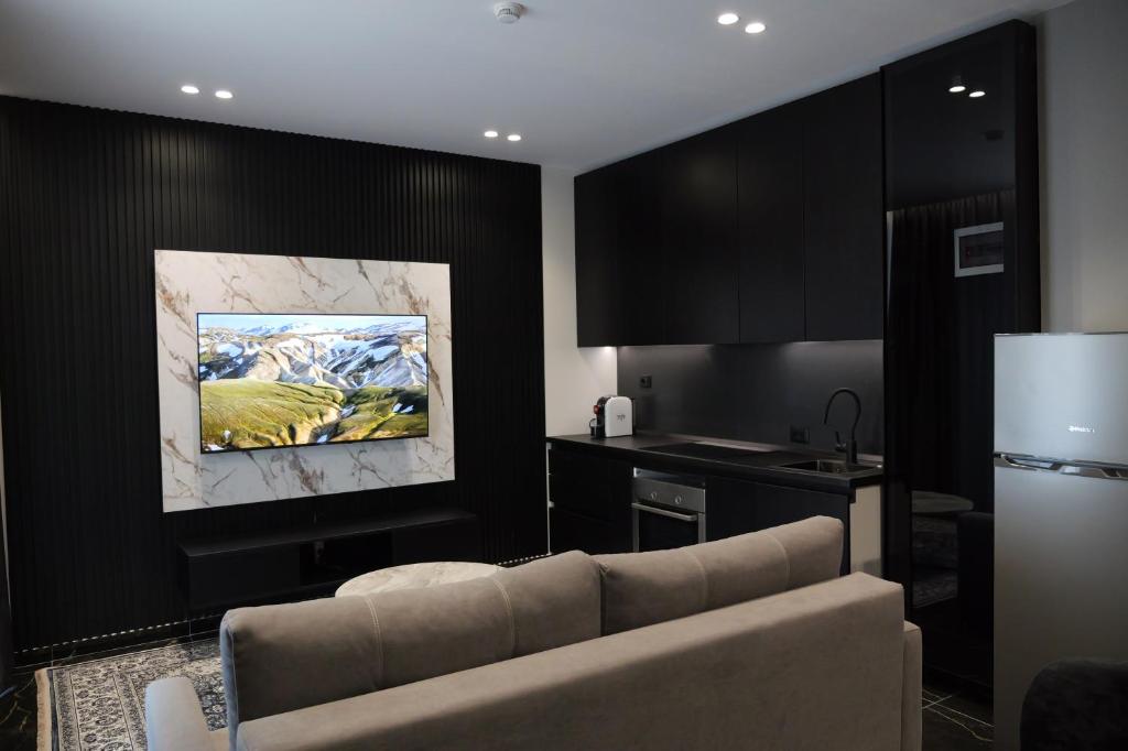 a living room with a couch and a kitchen at Prestige Apartments in Shkodër
