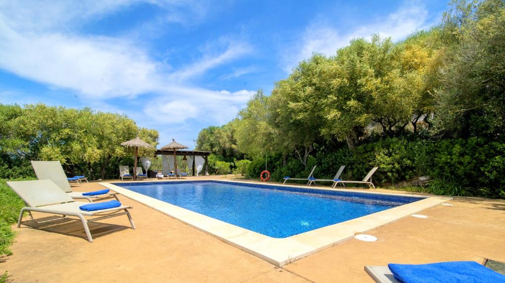 a swimming pool with lounge chairs next to a resort at Villa Tortuga con piscina in Manacor
