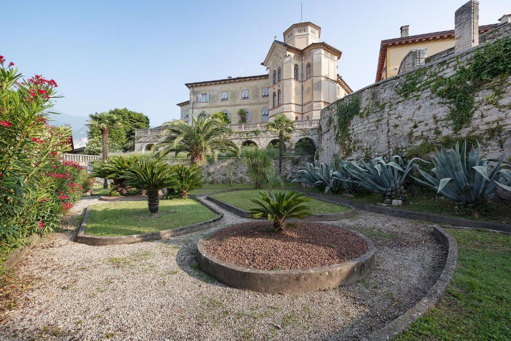 a building with a bunch of plants in a yard at La Guardiola in Riva del Garda