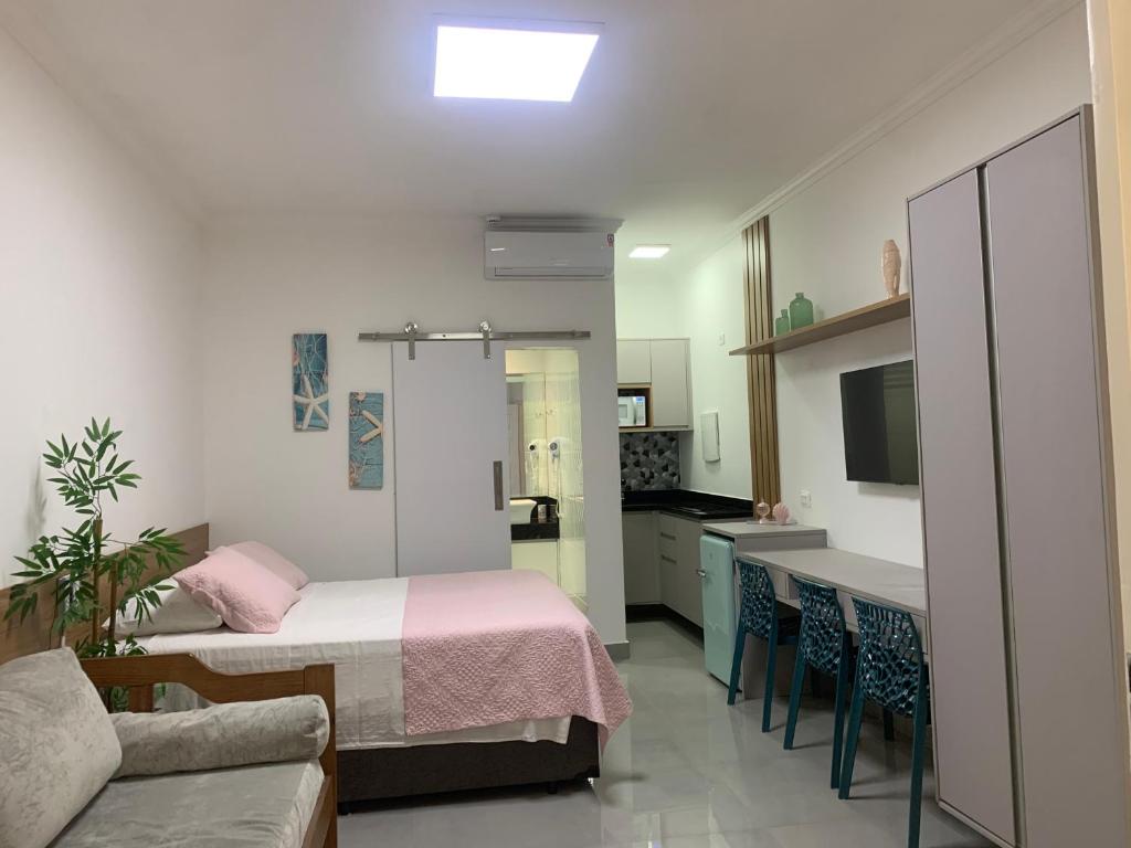 a small room with a bed and a kitchen at Amarílis Riviera-Estúdio A-209 in Bertioga
