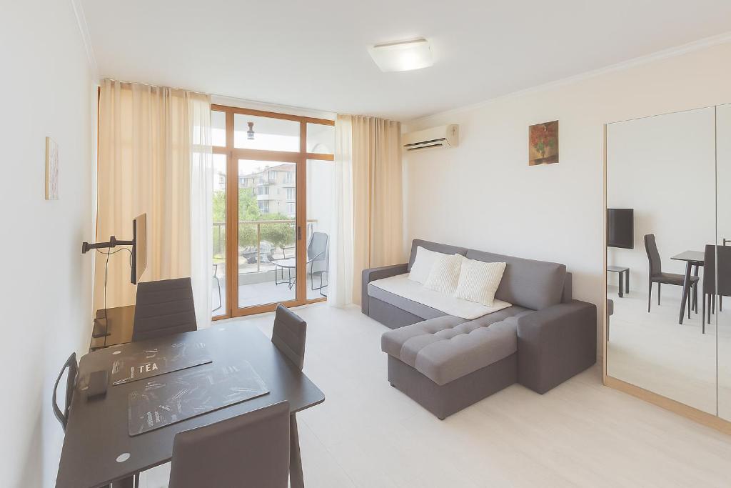 a living room with a couch and a table at Helios Seaview Apartment in Sveti Vlas
