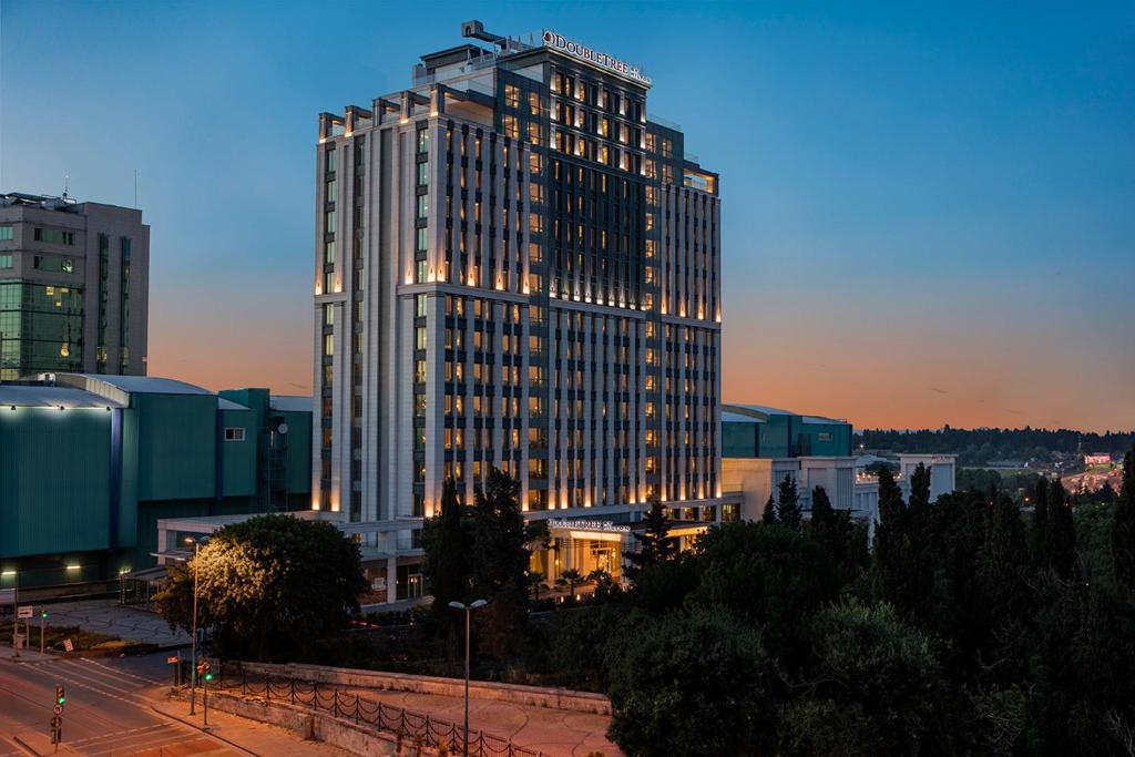un edificio alto con luces encendidas en una ciudad en Doubletree By Hilton Istanbul Topkapi, en Estambul