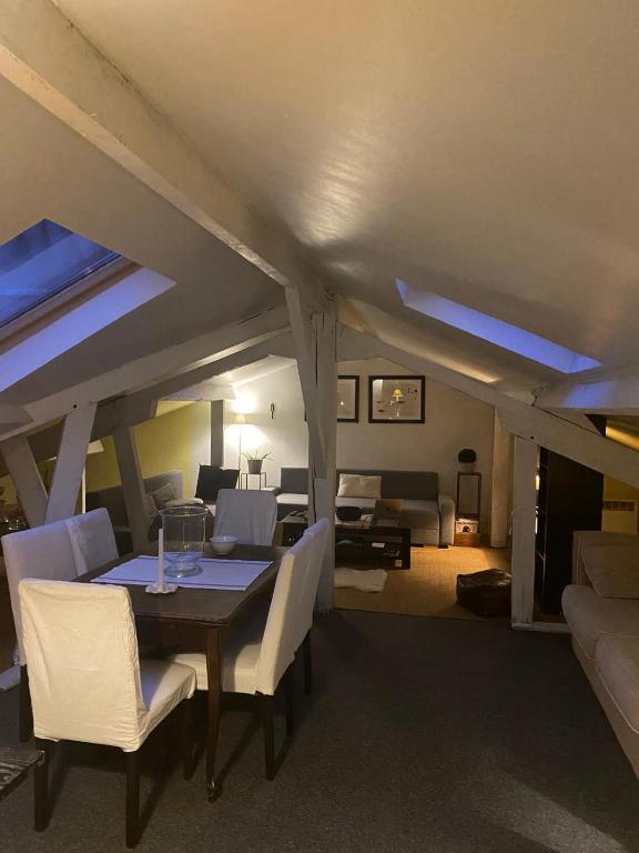 une salle à manger avec une table et des chaises et un salon dans l'établissement Duplex avec vue sur les toits de Paris Paris Expo Porte de Versailles, à Paris