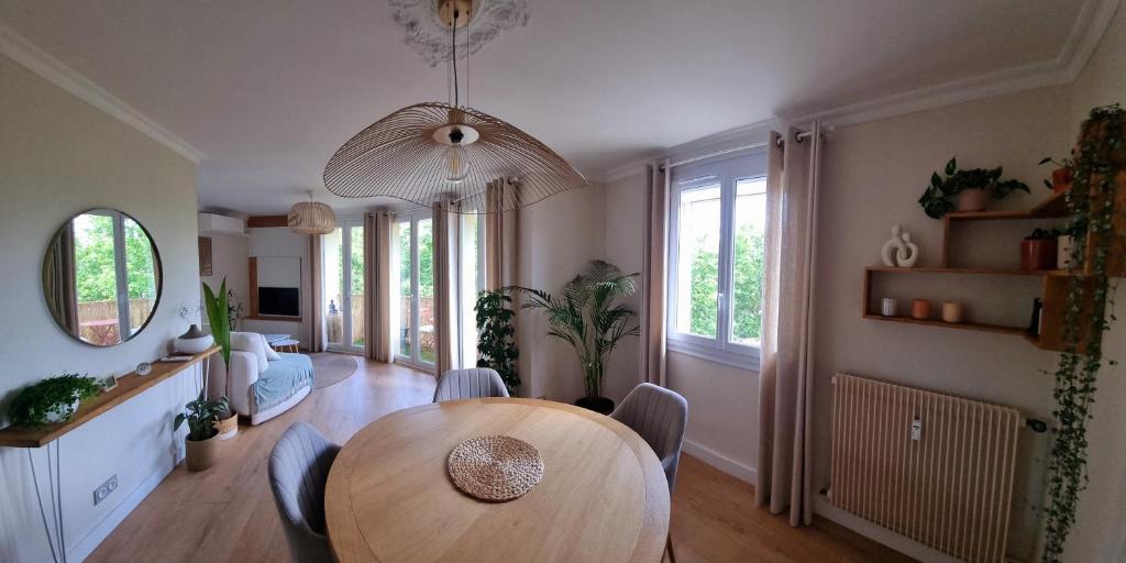 un salon avec une table et des chaises en bois dans l'établissement Instant suspendu, à La Celle-sous-Gouzon