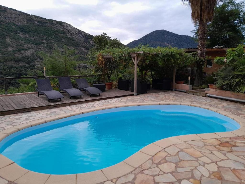 une piscine avec des chaises et des montagnes en arrière-plan dans l'établissement Casa Versini, à Balogna