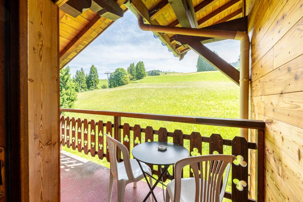 un patio avec une table et des chaises sur un porche dans l'établissement Studio 11 - Les Warrens, à Cohennoz