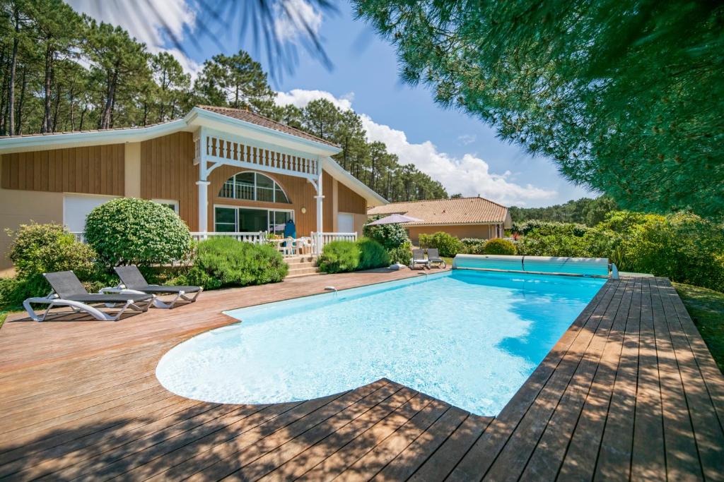 une piscine devant une maison dans l'établissement Lagrange Vacances - Atlantic Green, à Lacanau-Océan
