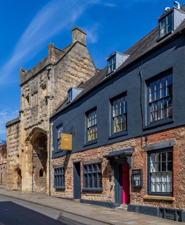 an old brick building on the corner of a street at The Ancient Gatehouse & Rugantino Restaurant in Wells