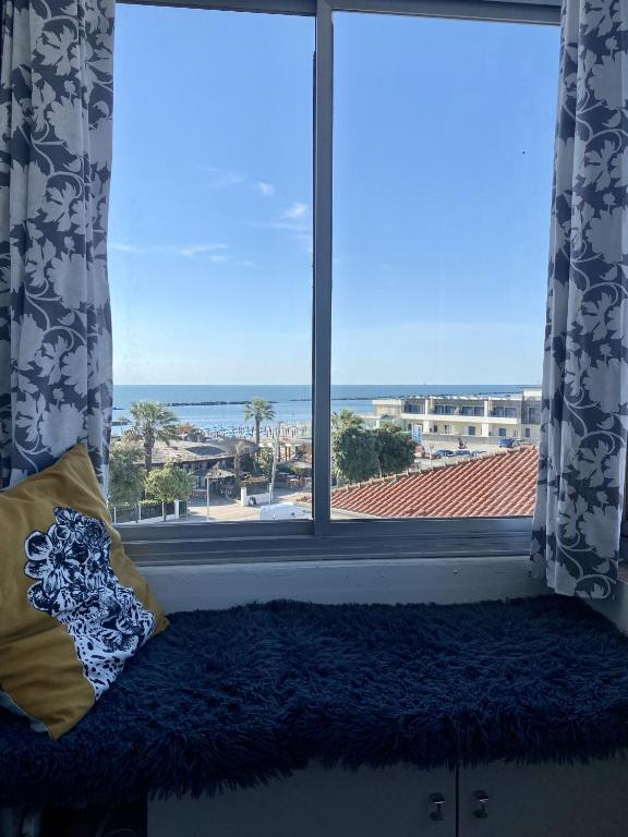 a window with a pillow and a view of the ocean at Casa Blu di Pomposa Vista Mare in Lido di Pomposa