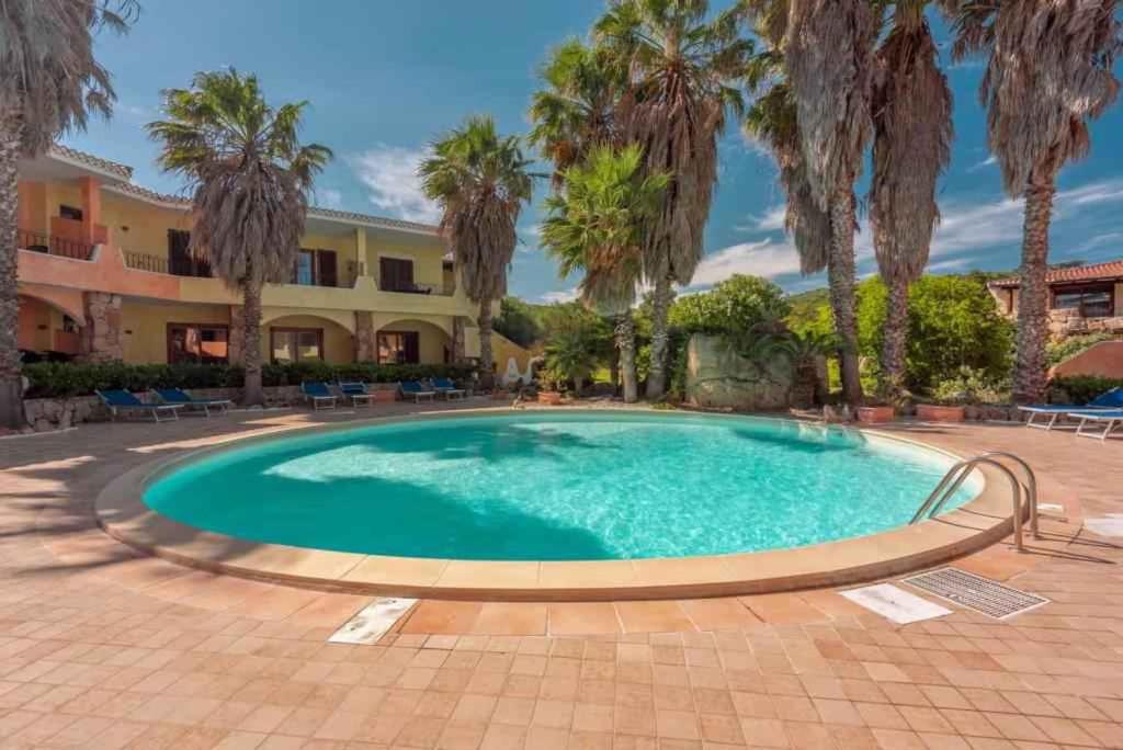 a large swimming pool with palm trees and a building at Apartment in Palau 44926 in Palau