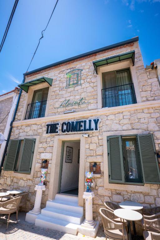 a building with tables and chairs in front of it at The Comelly Alaçatı in Çeşme