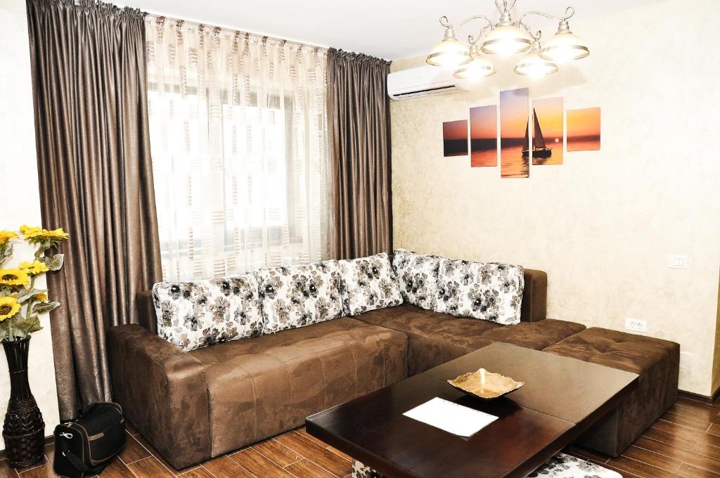 ein Wohnzimmer mit einem Sofa und einem Tisch in der Unterkunft Apartment Ovidius - by the beach in Constanţa