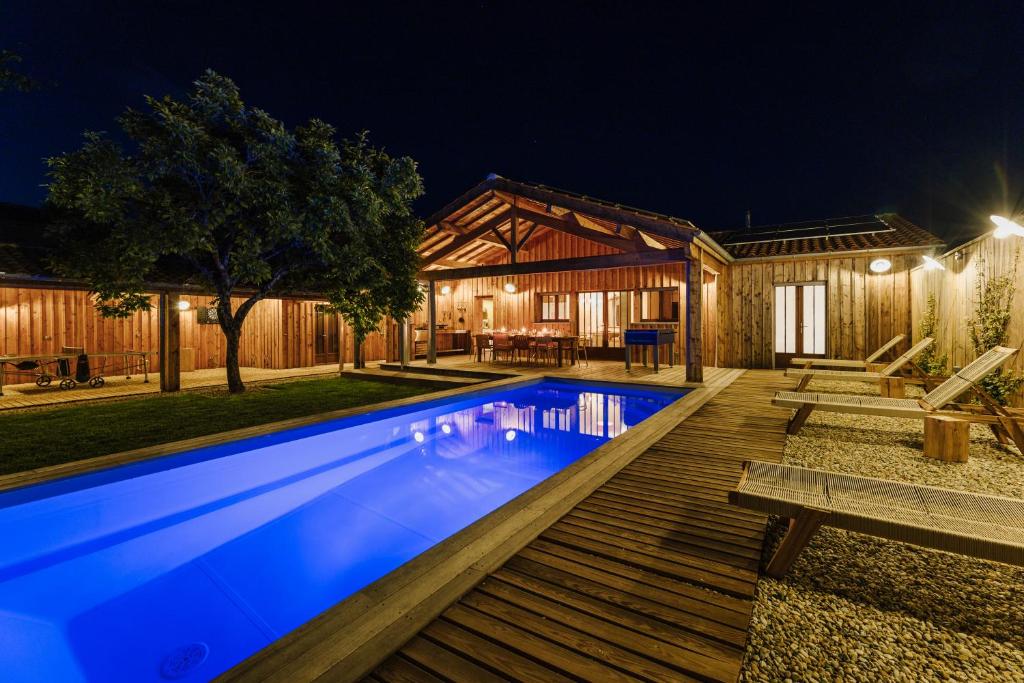 una casa con piscina por la noche en La Cabane du Naissain 5 stars, en Saint-Georges-dʼOléron
