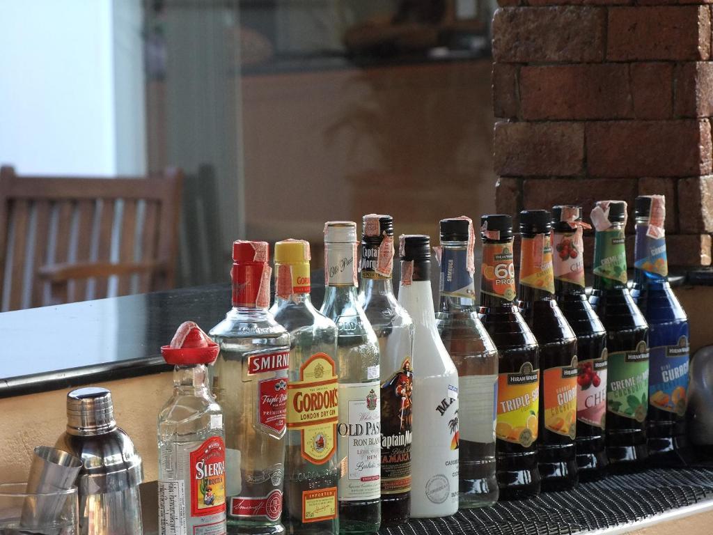 a group of bottles of alcohol sitting on a table at Katanoi Resort in Kata Beach