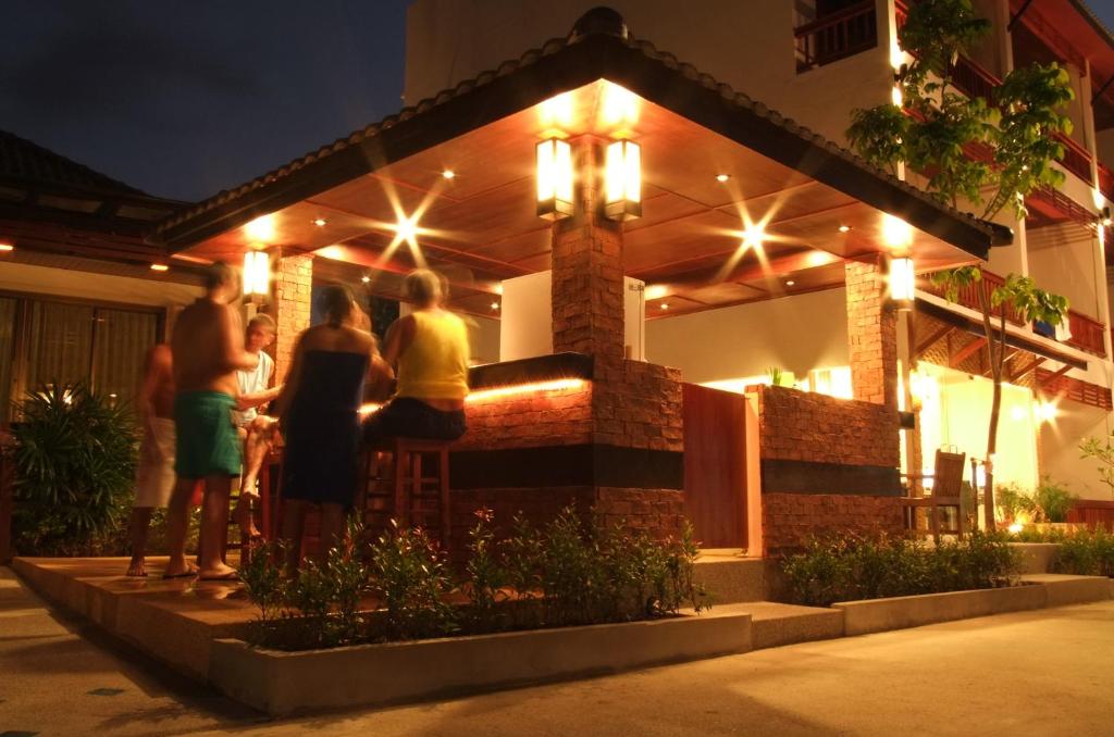 a group of people standing outside of a building at night at Katanoi Resort in Kata Beach