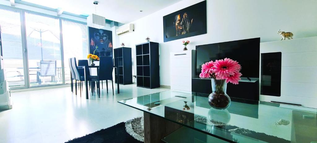 a vase with a pink flower on a glass table at Seasonal Living Lumen Triplex in Madrid