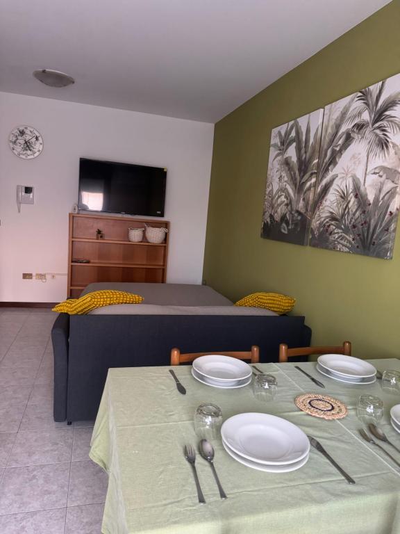 a room with a bed and a table with plates on it at Relax stefy apartment in Zelarino