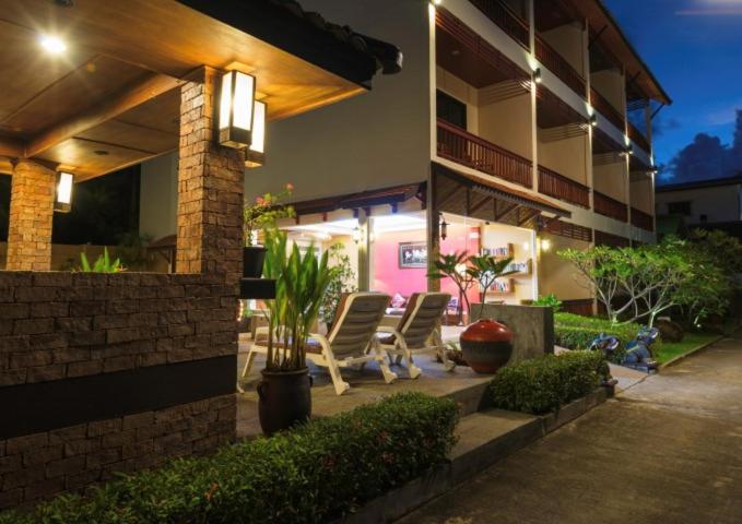 two chairs sitting outside of a house at night at Katanoi Resort in Kata Beach