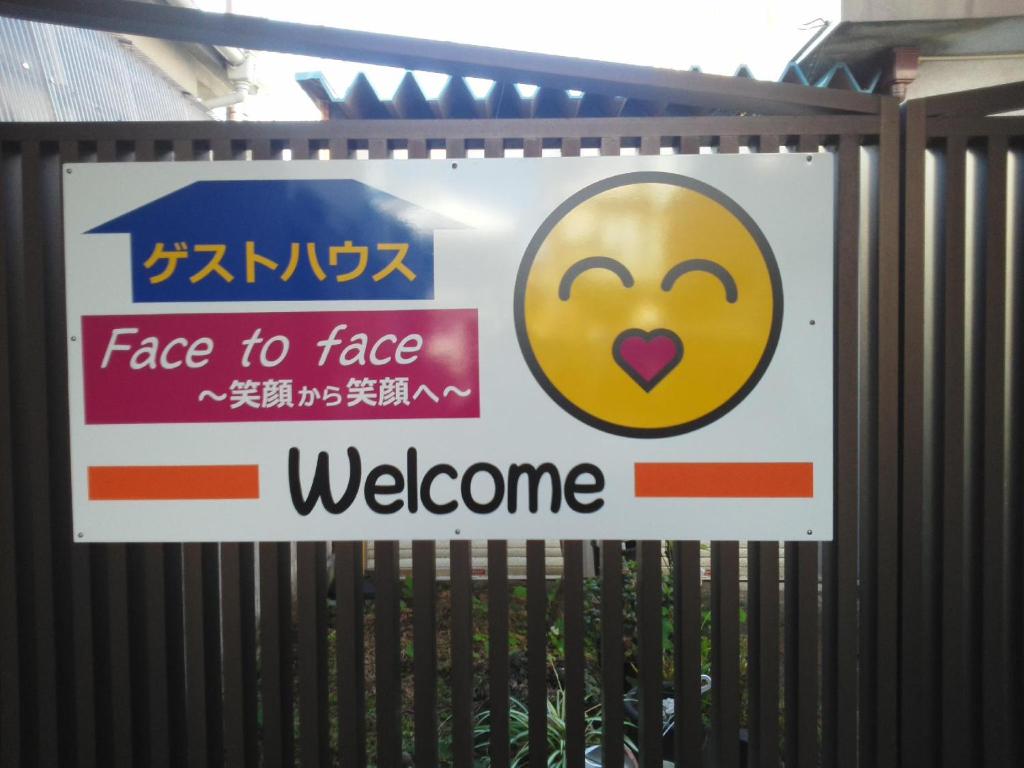 a sign for a gate to face welcome at Guesthouse Face to Face in Fujinomiya