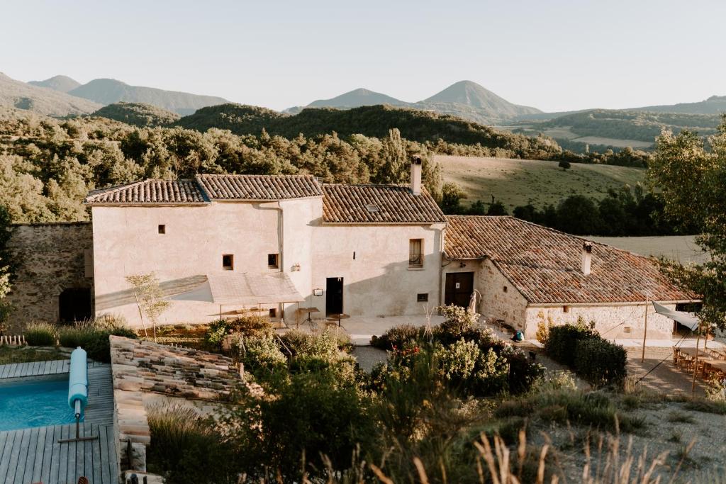 an old house with a pool in front of it at Les Nuits du Taris in Bourdeaux