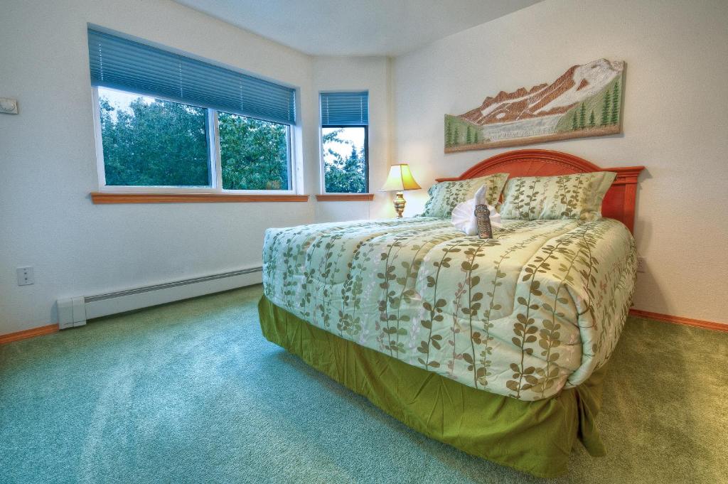 a bedroom with a bed and two windows at Frontier Suites Hotel in Juneau in Juneau