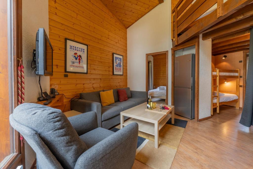 un salon avec un canapé et une table dans l'établissement La Corniche A18 - Snow and Trek, à Morzine