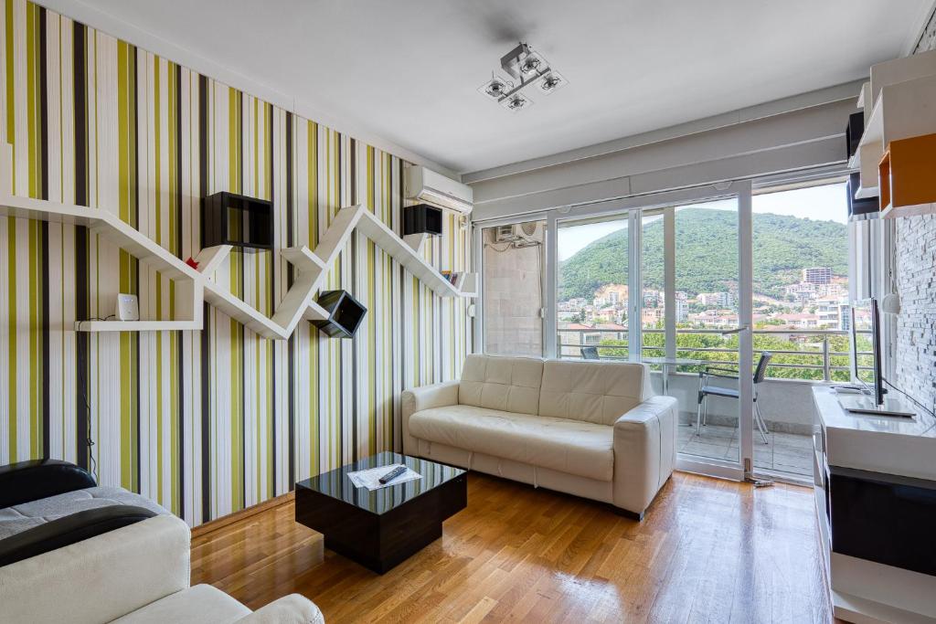 a living room with yellow and white striped walls at Studio apartment in the centre of Budva in Budva