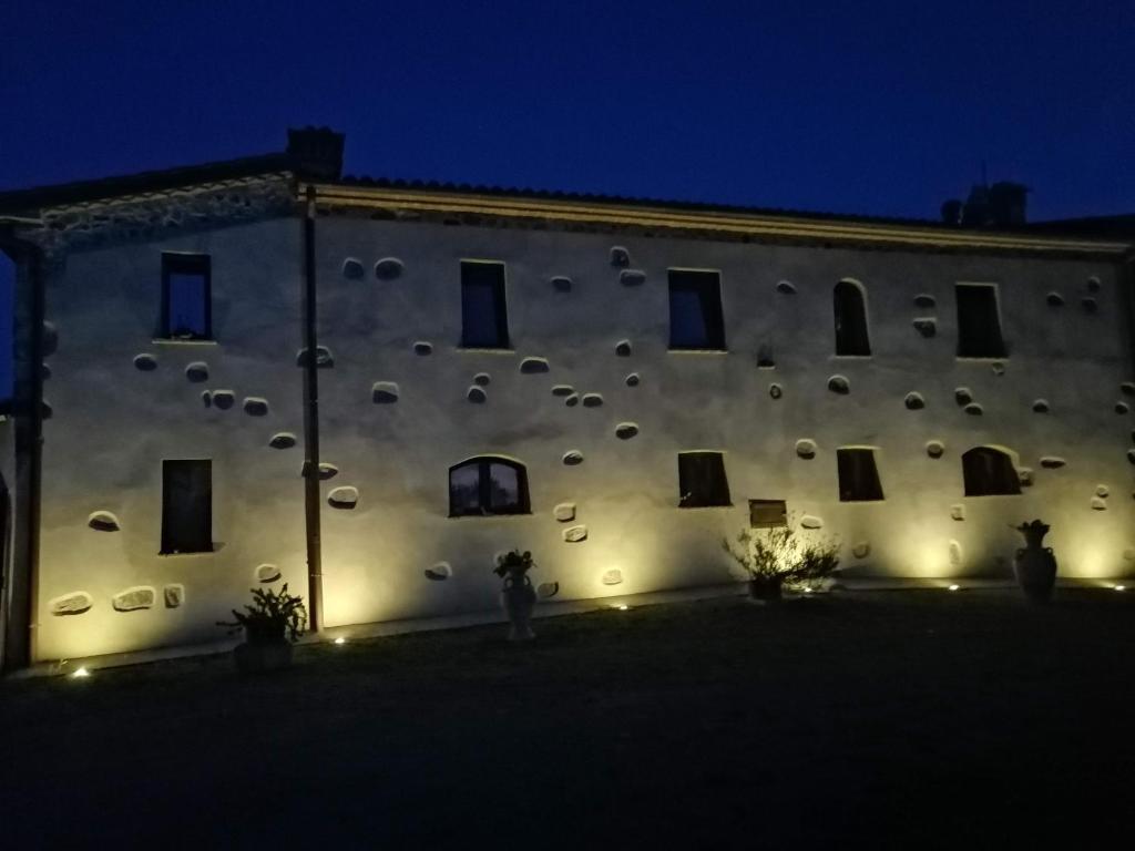 a building with a wall with many windows at night at Vecchio Casale Quercetino in Castel del Piano