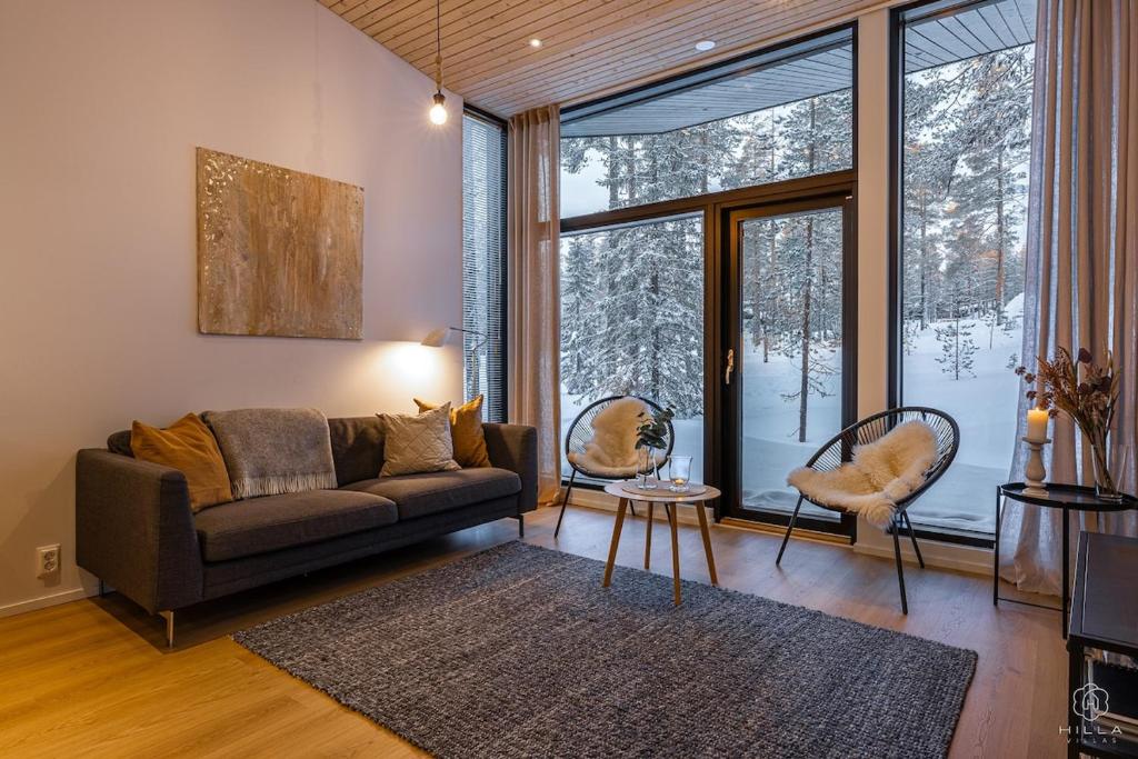 Una sala de estar con un sofá y una ventana grande. en Villa Suunnikas by Hilla Villas, en Ylläsjärvi