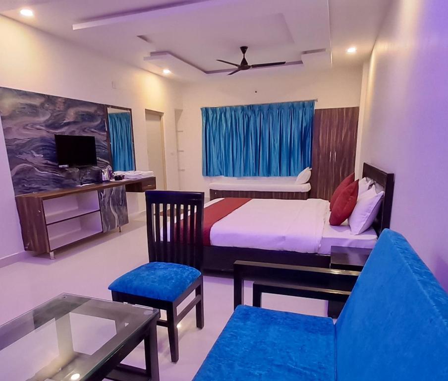 ein Schlafzimmer mit einem Bett und einem Tisch und Stühlen in der Unterkunft Valley Springs Resorts in Araku