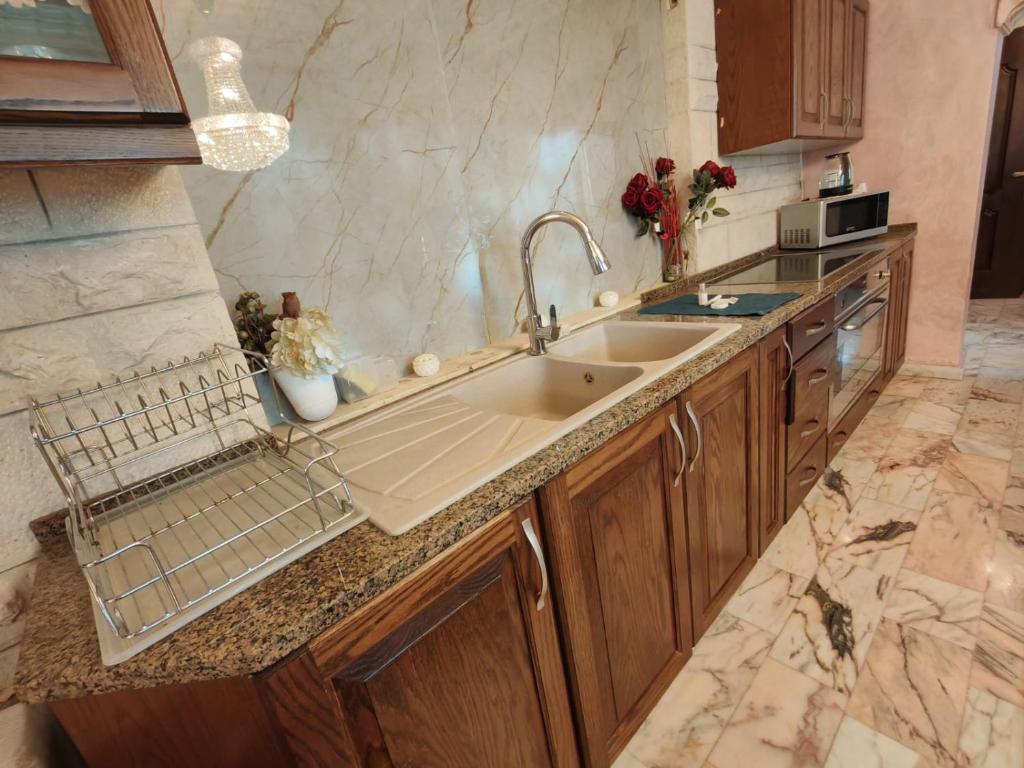 a kitchen with a sink and a counter top at شقة مفروشة في البنيات - بالقرب من جامعة البتراء in Amman