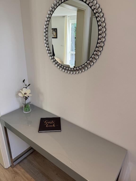 a table with a mirror and a book on it at Bungalow Benther Berg, Contactless Check-in, Vollsaniert und Renoviert 2025 in Ronnenberg