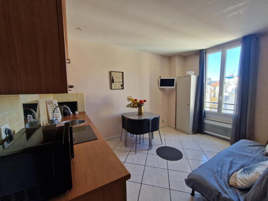 une cuisine et un salon avec un évier et une table dans l'établissement Le Centrale - Place Masséna, à Nice