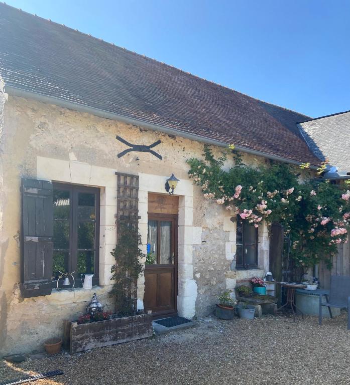 une ancienne maison en pierre avec une porte et des fleurs dans l'établissement Sunflower Cottage, à Genneteil
