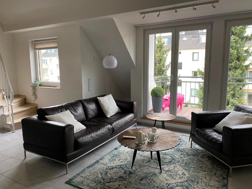 a living room with a leather couch and a table at Rheinblick Apartments in Cologne