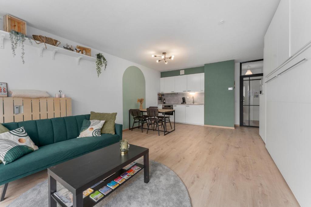 a living room with a green couch and a table at Lilyta B201 in De Haan