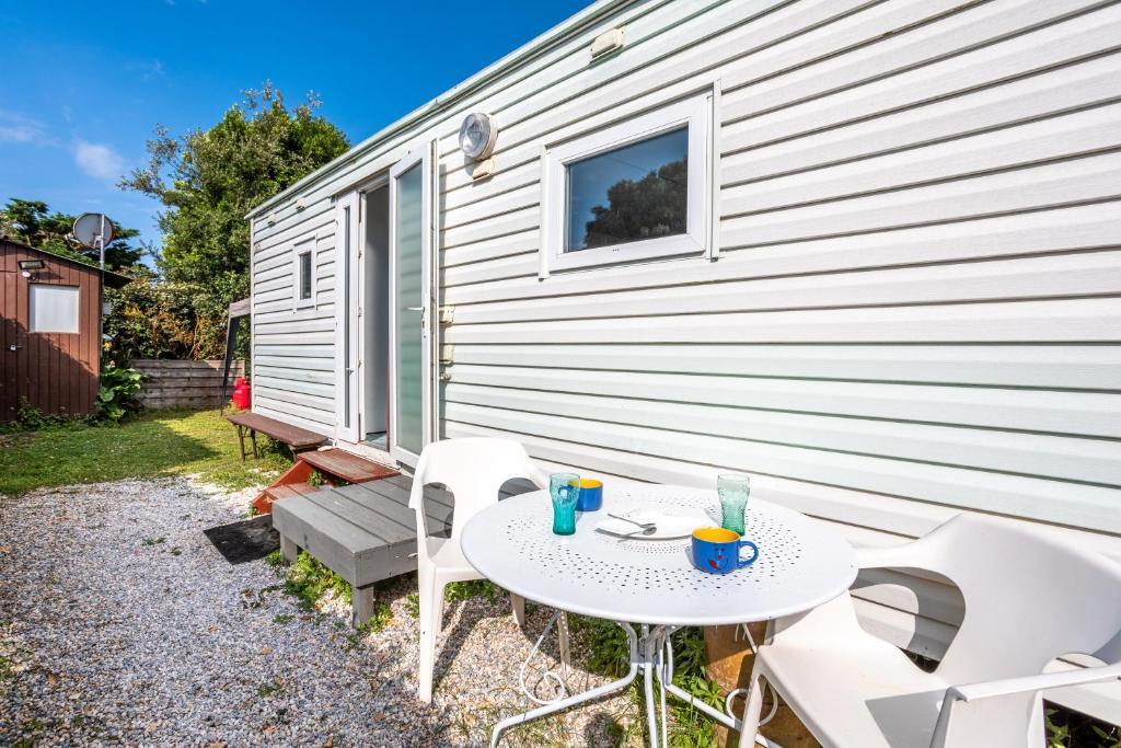un patio avec une table et des chaises à côté d'un bâtiment dans l'établissement La Belle Perrochoise de Jen, à Saint-Pierre-dʼOléron