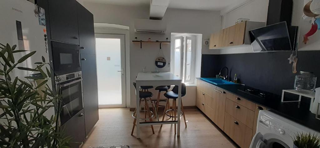 - une cuisine avec un comptoir et des tabourets dans l'établissement studios Magnan, à Nice