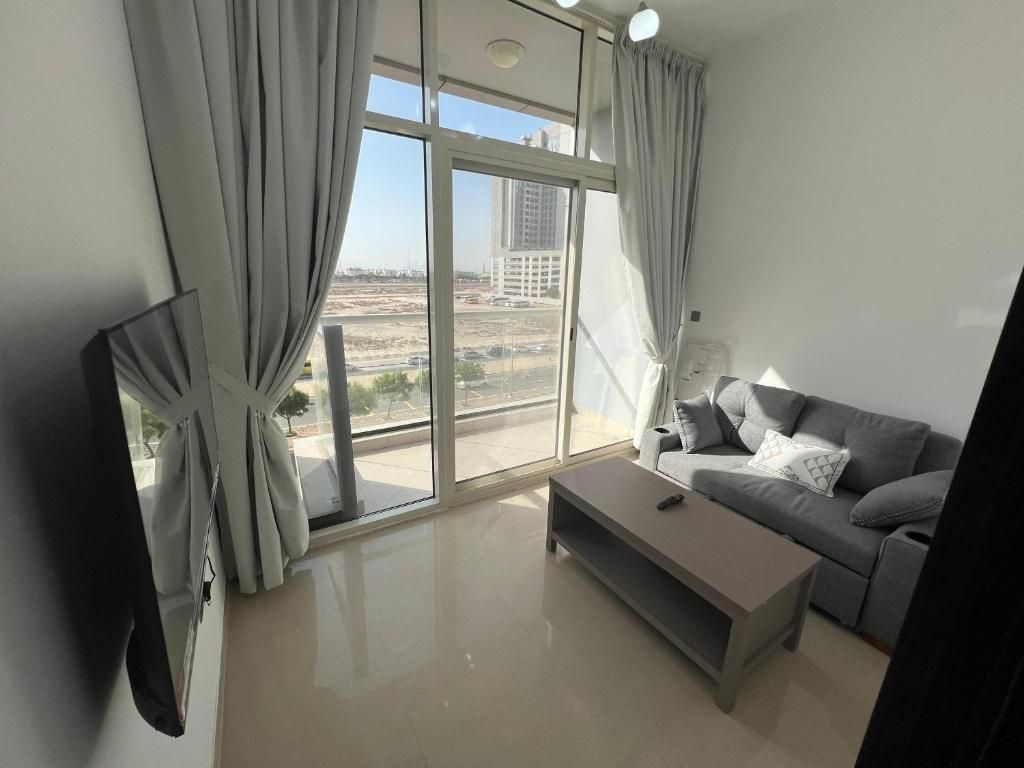 a living room with a couch and a large window at Dubai Silicon Oasis Rental Apartments in Dubai