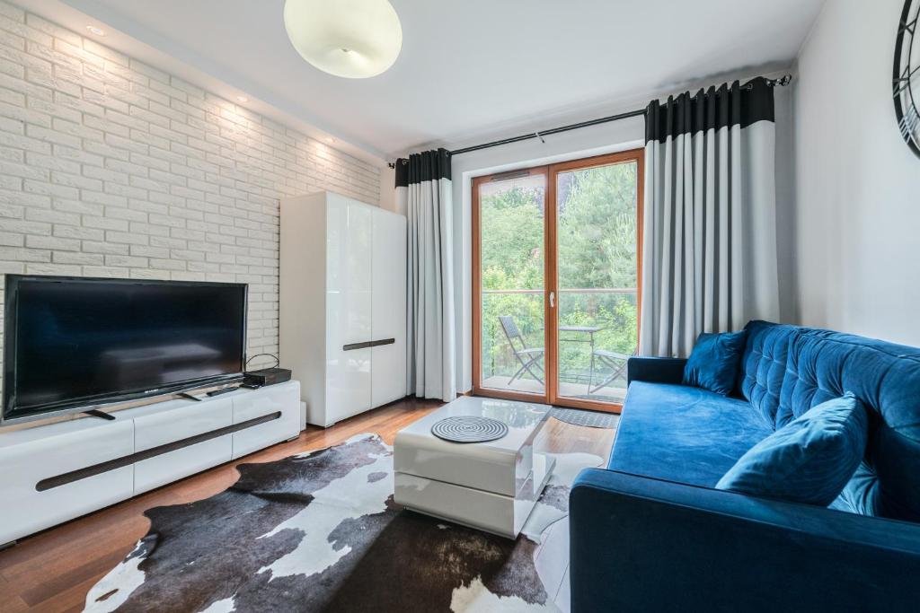 un soggiorno con un divano blu e una TV di Sopot Kamienny Potok by NorthSide Apartments a Sopot