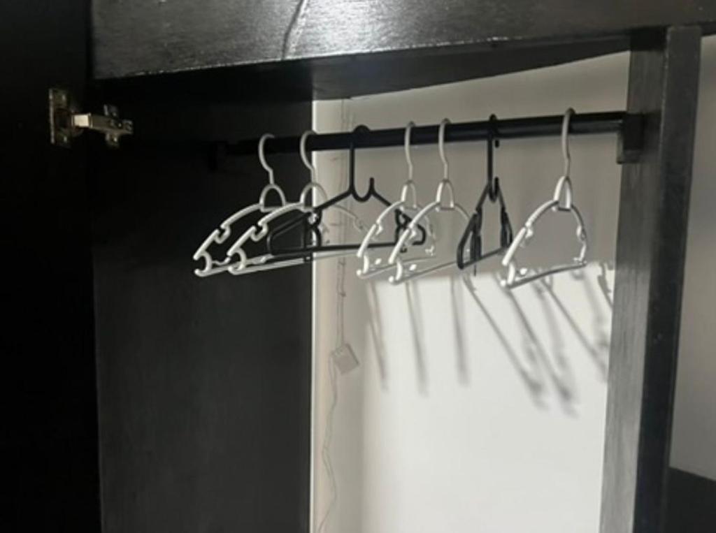 een rek met verschillende gebruiksvoorwerpen aan de muur bij HutofHappiness in Thongsala