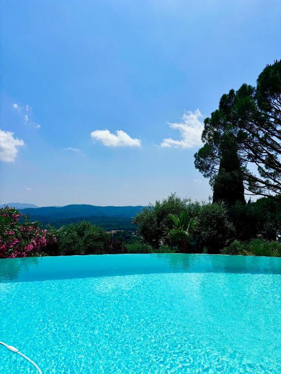 une piscine bleue avec un arbre en arrière-plan dans l'établissement Les Lodges de Saint Cassien, à Montauroux
