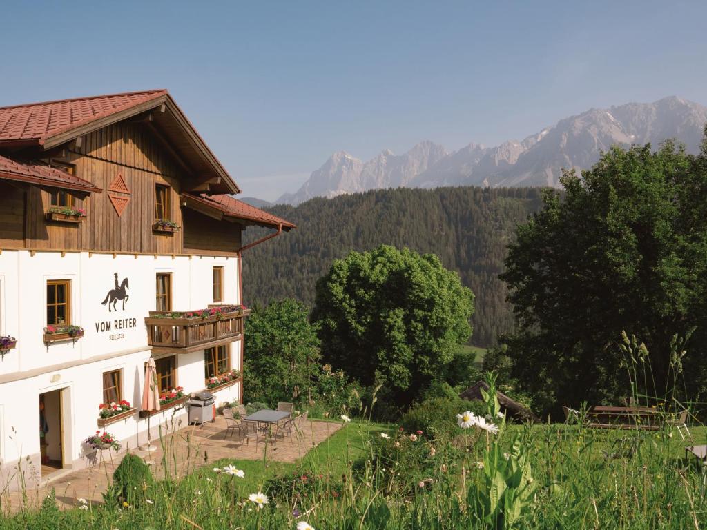 a large white building with a table in a field at VOM REITER, Ferienwohnung am Bauernhof mit Bergblick und privater Infrarotkabine, Inklusive Sommercard in Schladming