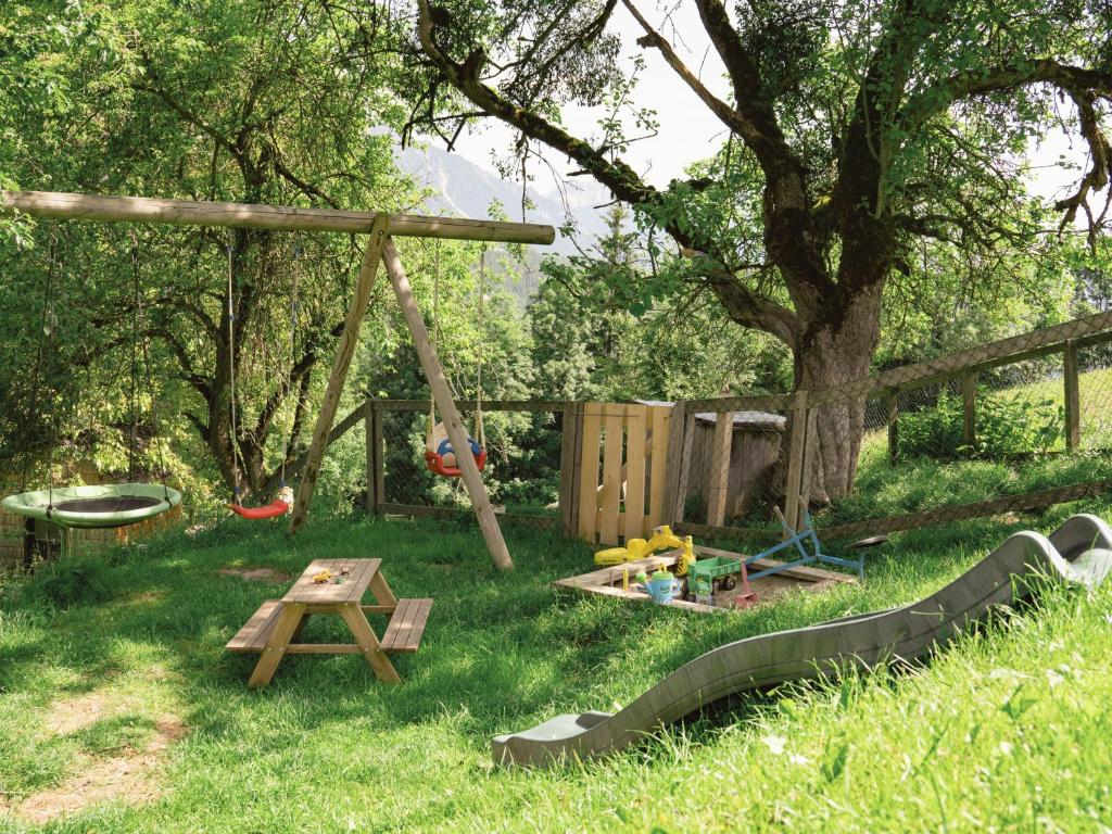 a playground with a table and a swing in the grass at VOM REITER, Ferienwohnung am Bauernhof mit Bergblick und privater Infrarotkabine, Inklusive Sommercard in Schladming