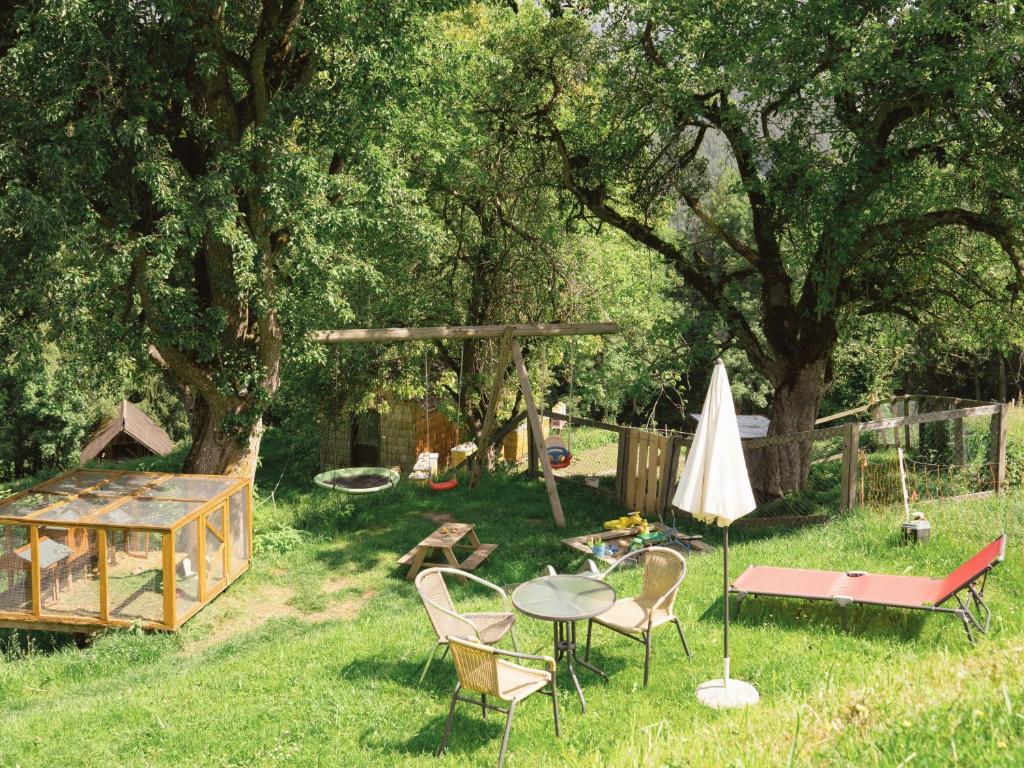 a backyard with a table and chairs and an umbrella at VOM REITER, Ferienwohnung am Bauernhof mit Bergblick und privater Infrarotkabine, Inklusive Sommercard in Schladming