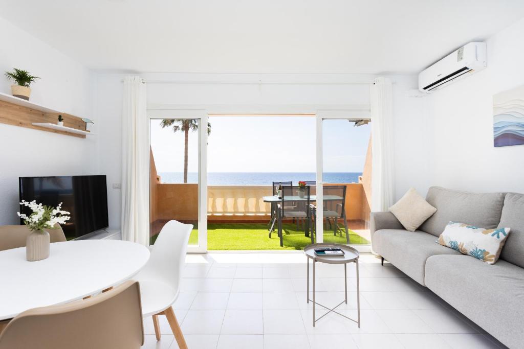 a living room with a couch and a table at Home2Book Duplex Rotia Caletillas Oceanview in Candelaria