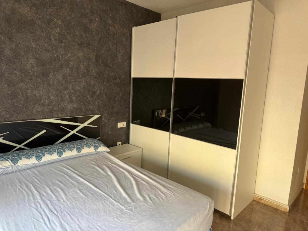 a bedroom with a bed and a large white cabinet at Apartamento terramarzarron in Mazarrón