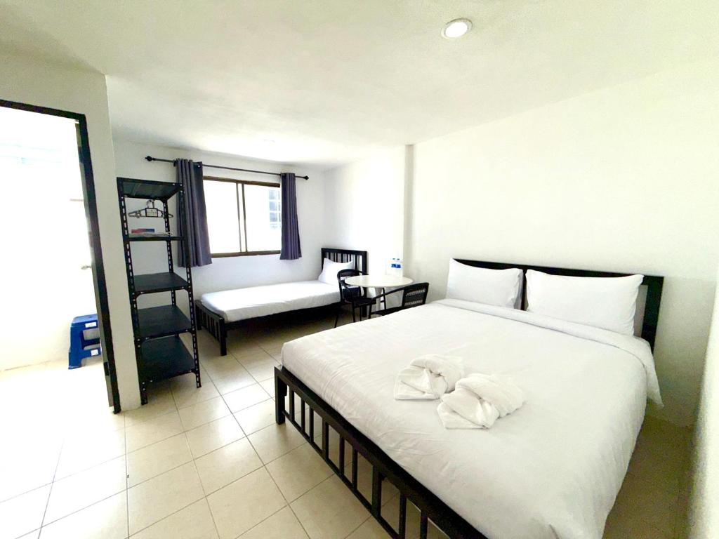 a bedroom with a large white bed with towels on it at Patong Canal Villa 210 in Patong Beach