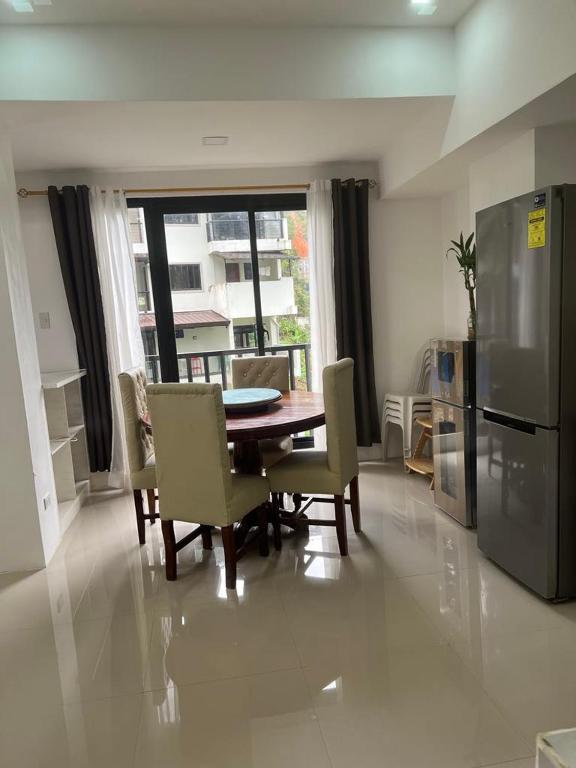 a kitchen with a table and chairs and a refrigerator at MG Transient House in Baguio