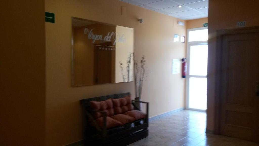 a waiting room with a chair and a mirror at Hostal Virgen Del Pilar in Baza